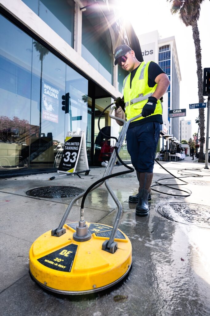 a man in a yellow vest is cleaning the street